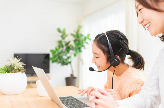 キッズ向けオンライン英会話で小学生の英検レッスン受講中の小学生と横で見守る保護者