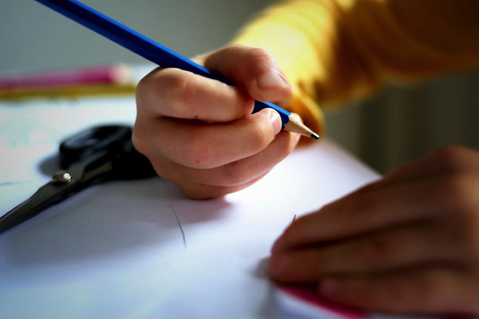 英検準2級プラスの新設・中学受験・AI時代と英語ライティングの重要性を感じながらライティングに取り組む小学生の手の様子